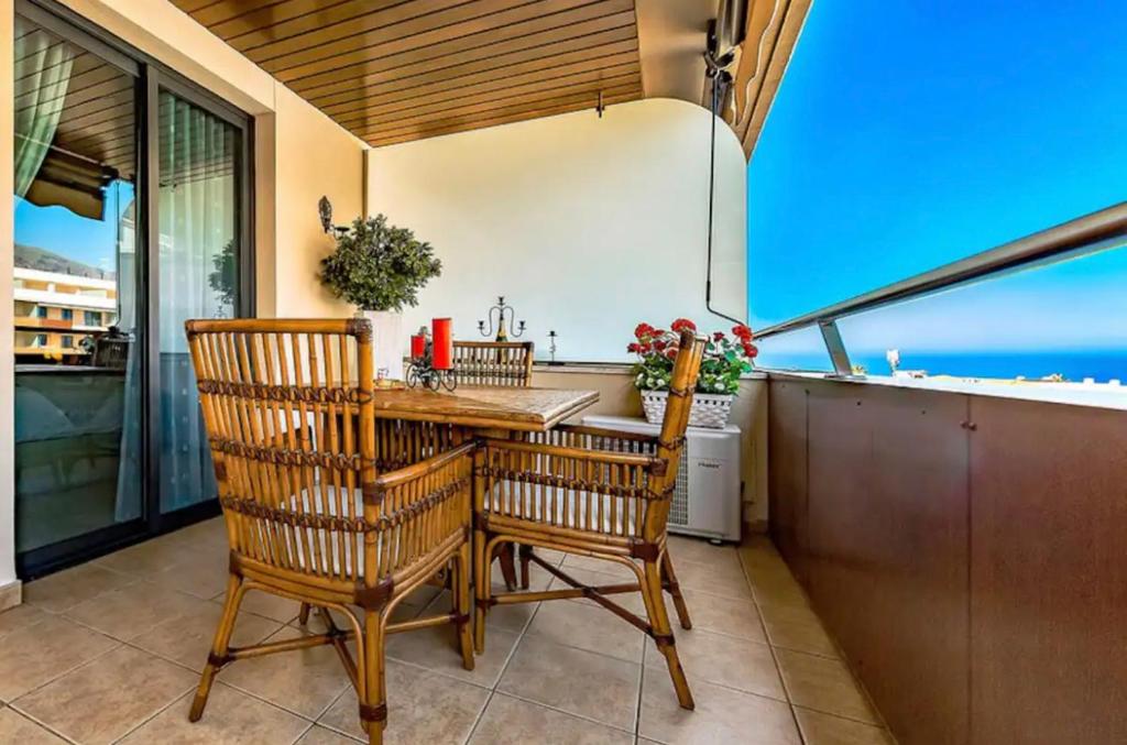 une salle à manger avec une table et des chaises sur un balcon dans l'établissement Balcón De Los Gigantes, Puerto de Santiago, à Puerto de Santiago