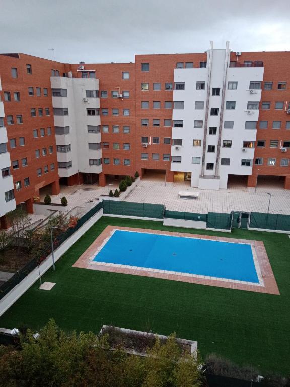 a swimming pool in front of a large building at La casita de Miguel, con garaje y piscina in Zamora