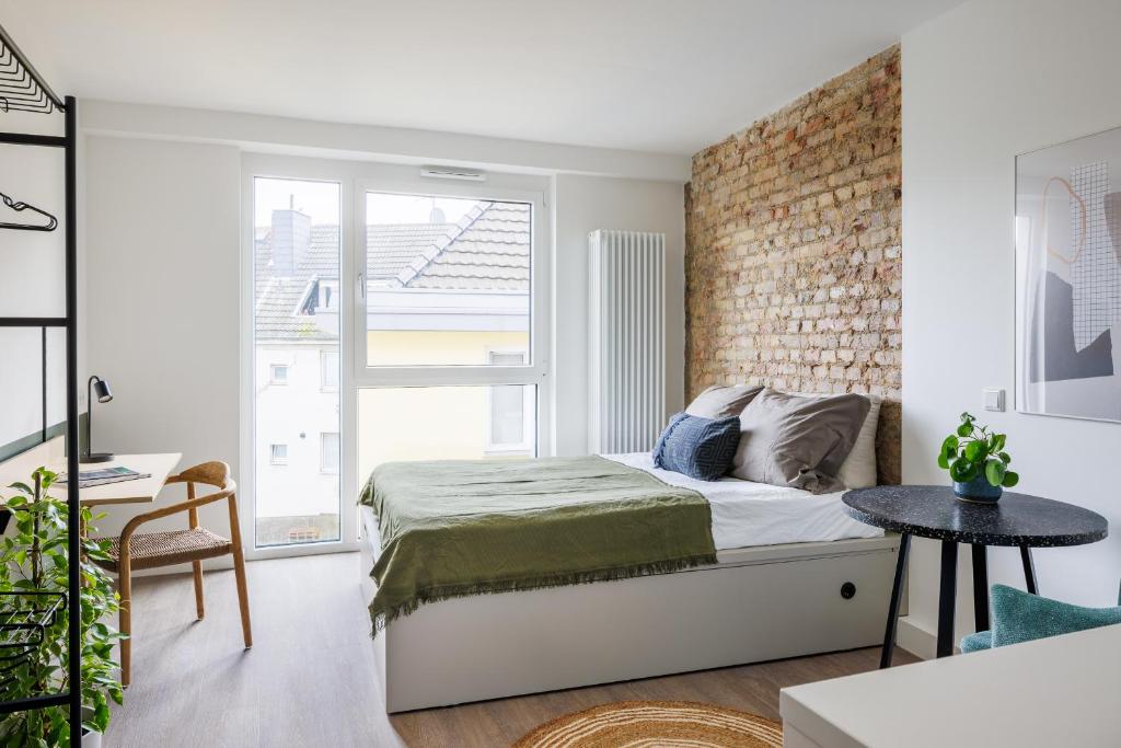 a bedroom with a bed and a brick wall at POHA House Büchel in Aachen