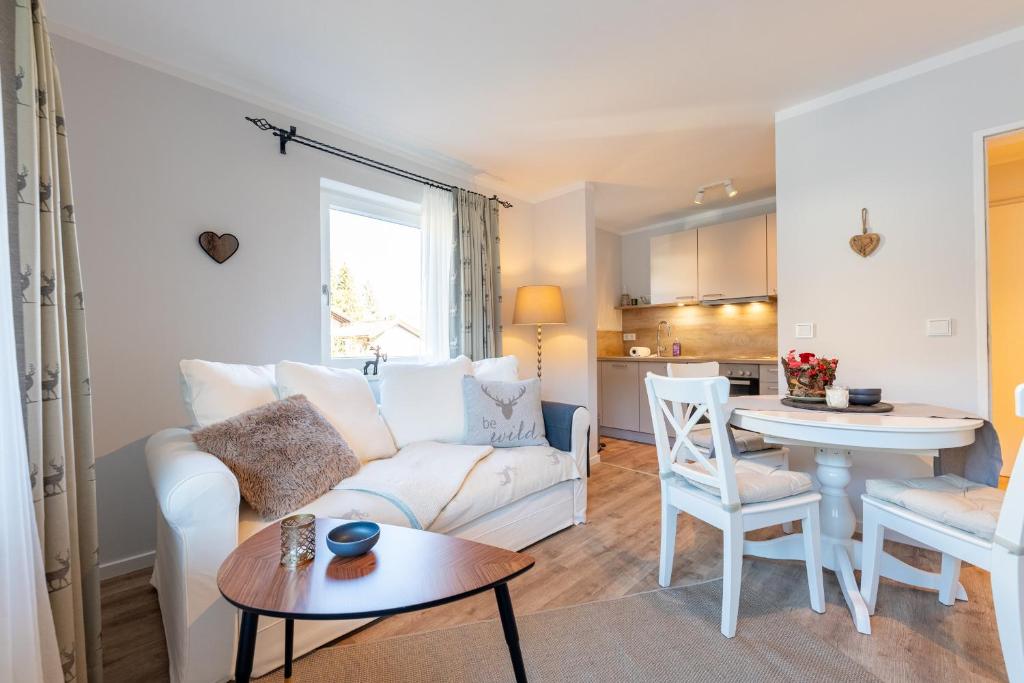 a living room with a white couch and a table at Bergjuwel in Garmisch-Partenkirchen