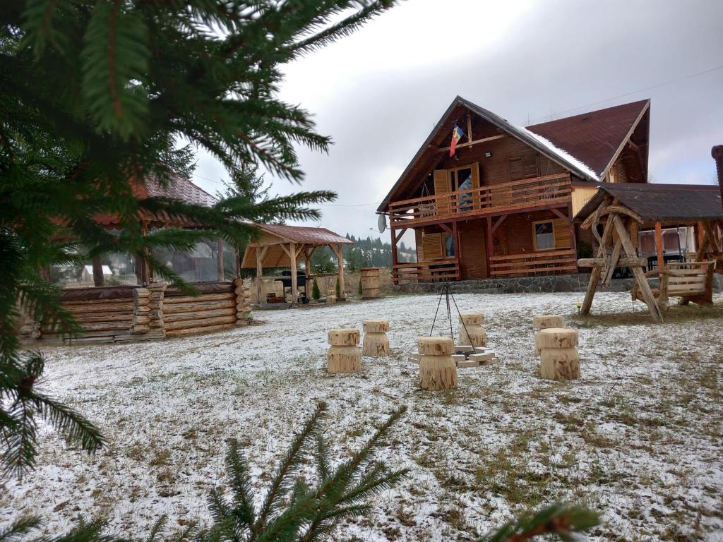 a playground in front of a log cabin at Cabana Dani in Vatra Dornei