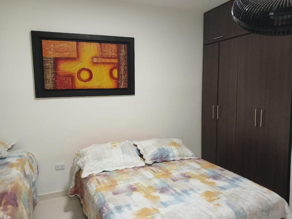 1 dormitorio con 1 cama y una pintura en la pared en HABITACIÓN INDEPENDIENTE y APARTAESTUDIO MONOAMBIENTE, en Barranquilla