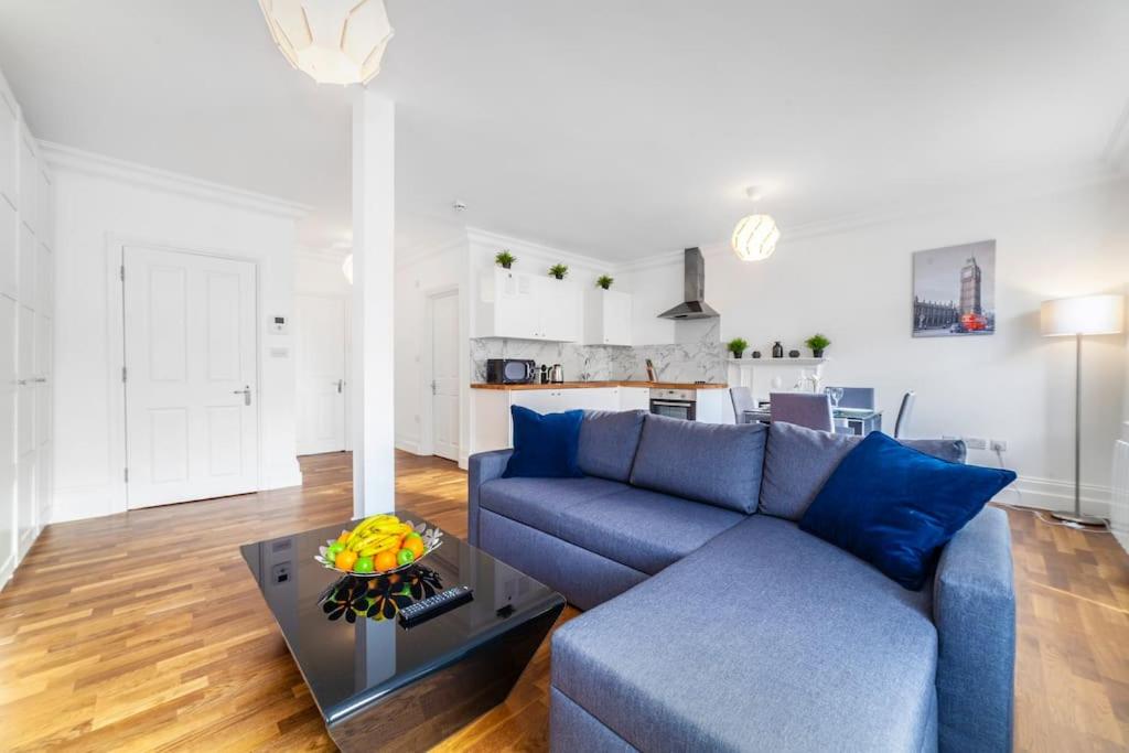 a living room with a blue couch and a table at Brand New Self-Contained 1 BDR Apt in Paddington in London