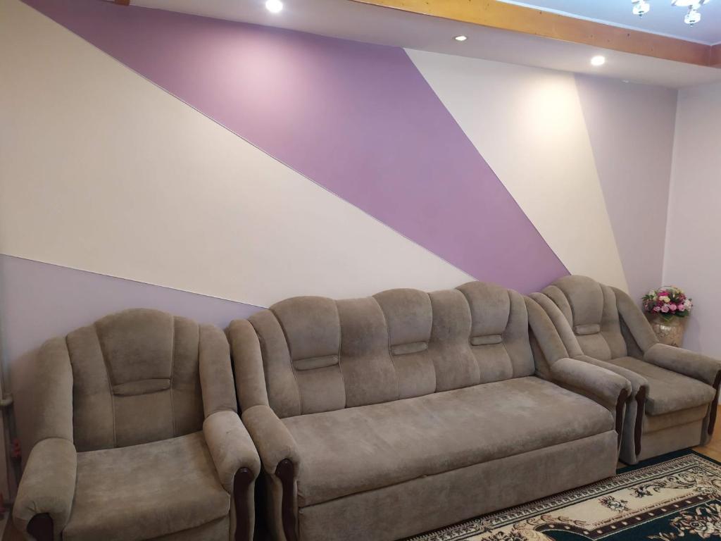 een bank in een woonkamer met paarse muren bij Dushanbe intourist apartment in Dushanbe