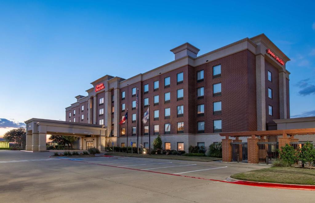 um hotel com um parque de estacionamento em frente em Hampton Inn & Suites Dallas-Allen em Allen