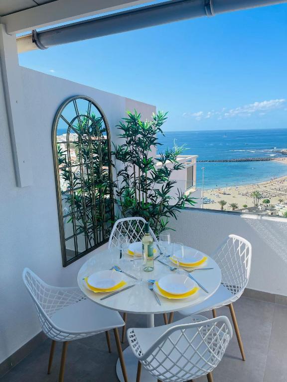 La Dolce Vita Penthouse 2 Bedroom Apartment في أرونا: طاولة بيضاء وكراسي مطلة على المحيط