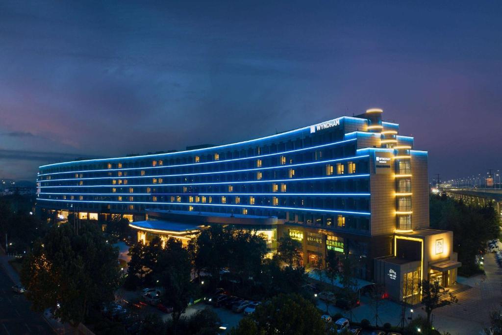 um grande edifício com luzes acesas à noite em Wyndham Qingdao em Qingdao