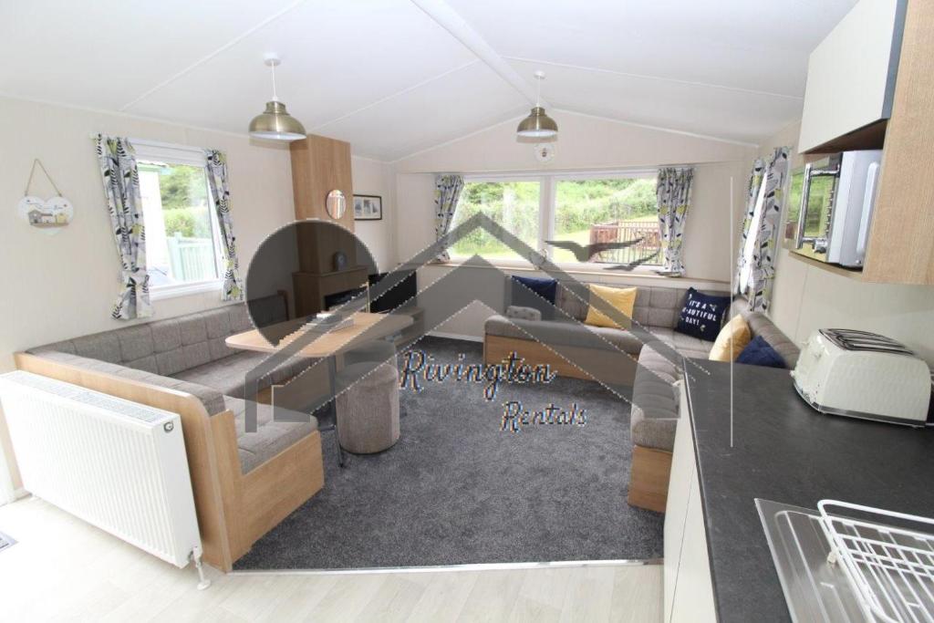 a living room with a couch and a table at Serenity - 8 Berth 3 Bedroom Static Caravan in Heysham