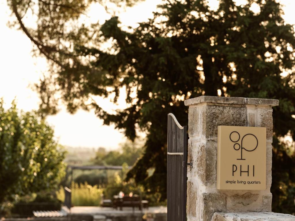 Um sinal que diz Phil numa cerca de pedra. em Phi Simple Living Quarters em Akrotiri