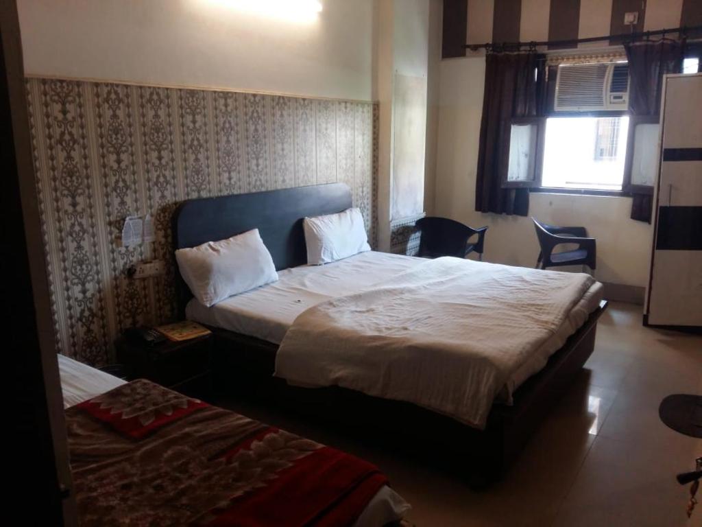 a hotel room with two beds and a window at Hotel Shiva Palace haridwar nearby bus and railway station in Haridwār