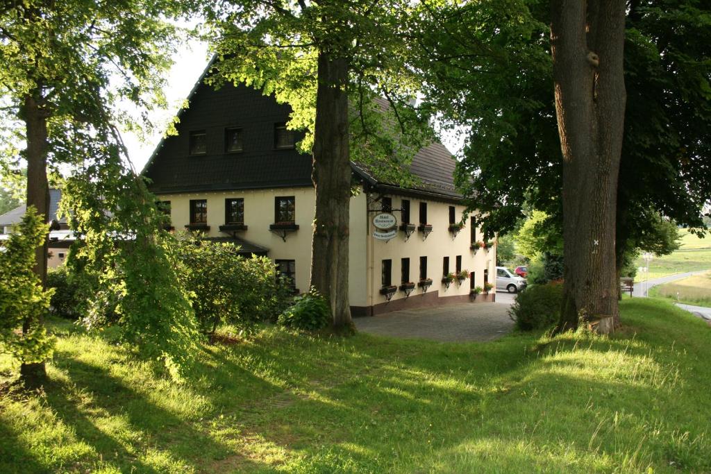 a white house with trees in front of it at Hotel-Restaurant Haus Berkenbaum in Kierspe