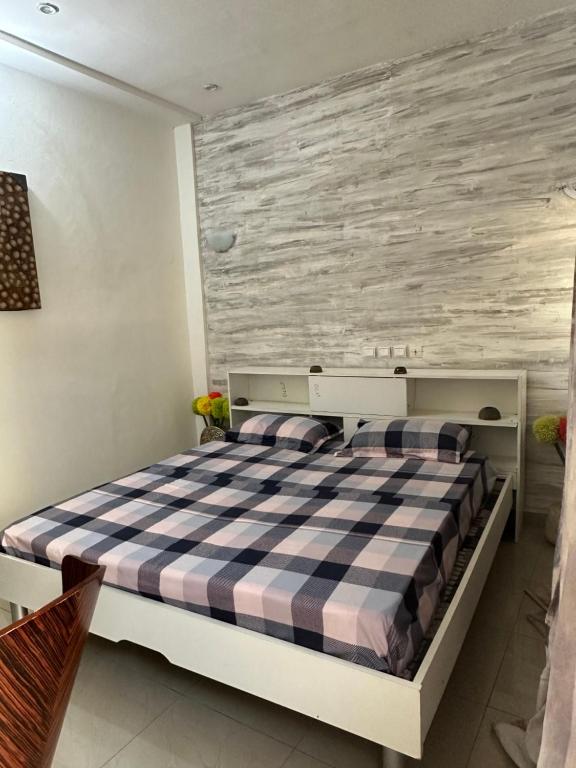 een slaapkamer met een bed en een houten muur bij Baï résidence in Cotonou