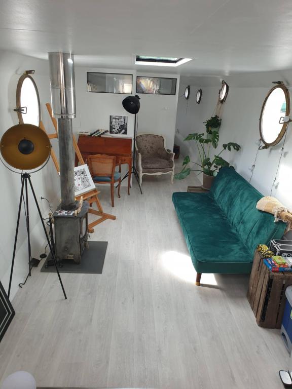 sala de estar con sofá verde y piano en Peniche C'est La Vie, en Les Grésillons