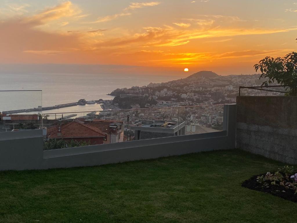 een uitzicht op de zonsondergang vanuit een huis bij Myrtus - House with sea view and garden in Funchal