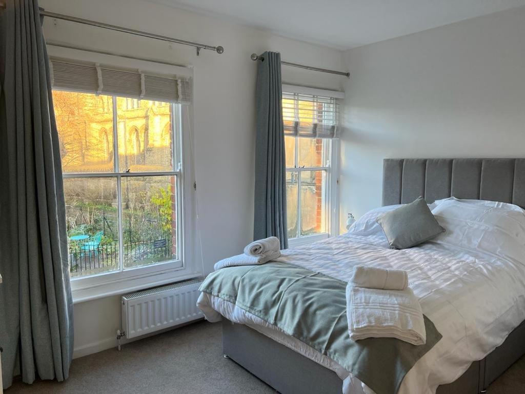 a bedroom with a bed and two windows at 42 Church Row - 2 beds and 2 bathrooms in Bury Saint Edmunds