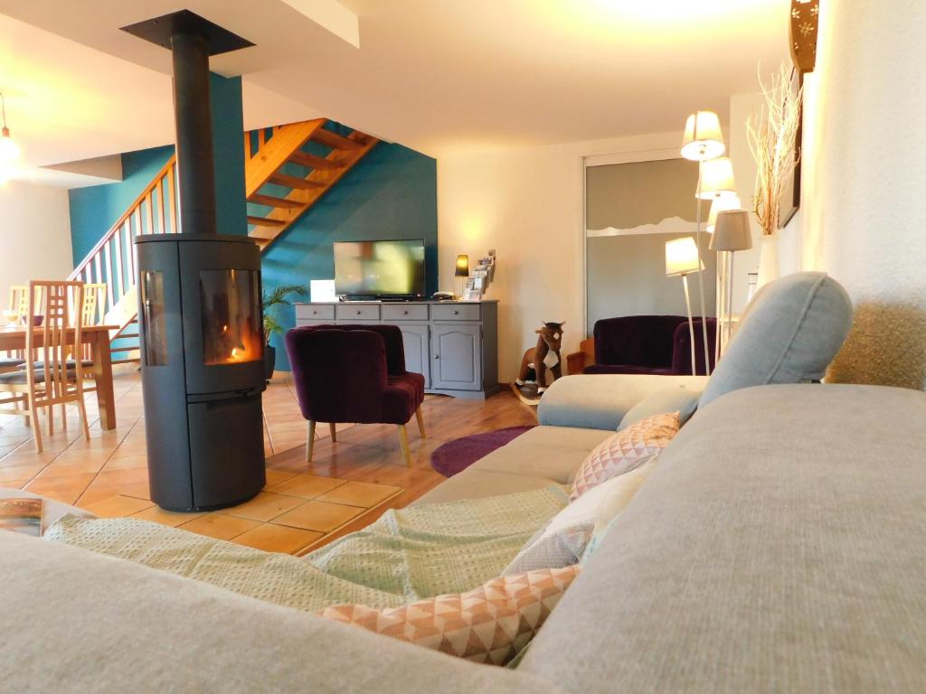 Gites et Cocon des Puys في Nébouzat: غرفة معيشة مع أريكة ومدفأة