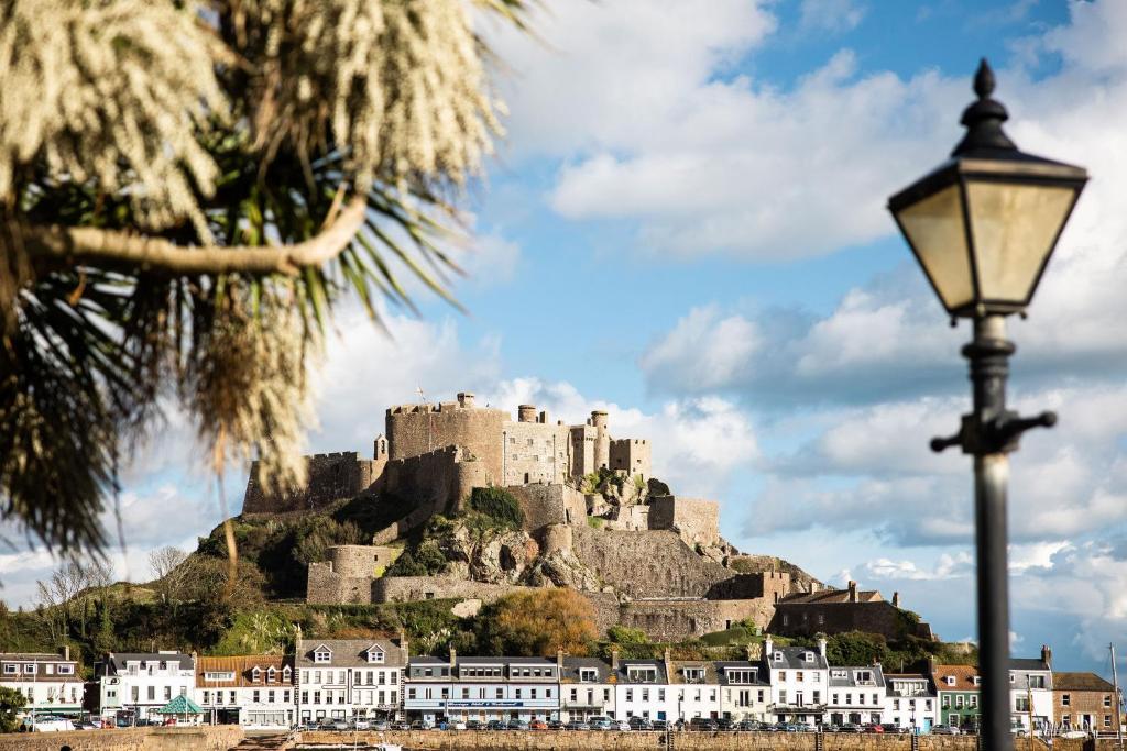 um castelo no topo de uma colina com uma luz de rua em The Moorings Hotel & Restaurant em Gorey