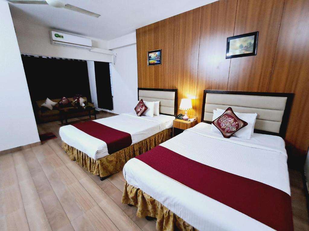 ein Hotelzimmer mit 2 Betten und einem Sofa in der Unterkunft GR MEET & GREET in Dhaka
