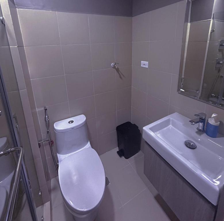 a white bathroom with a toilet and a sink at Mall of Asia_Pasay Condotel with Massage Chair and PS4- Stellar Suites in Manila