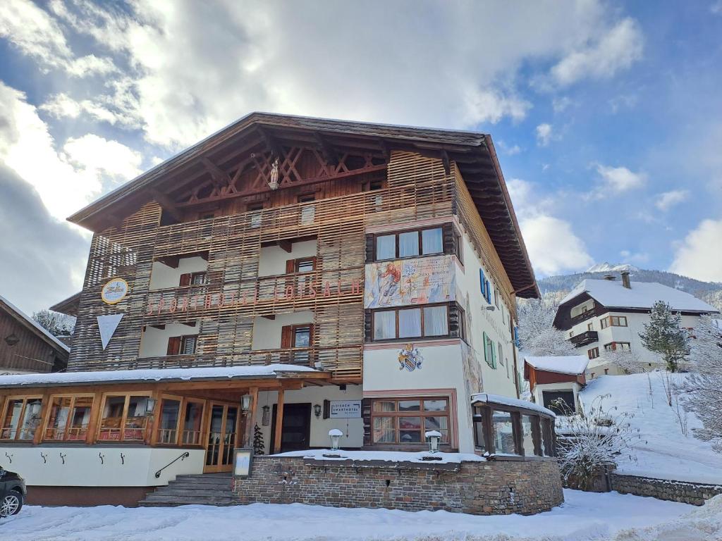 ein großes Holzgebäude im Schnee in der Unterkunft Loisach Smarthotel by keyone in Lermoos