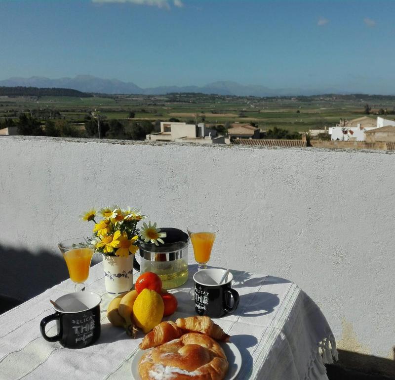 einen Tisch mit einem Teller Brot und Obst darauf in der Unterkunft YourHouse Cas Forner in Maria de la Salut