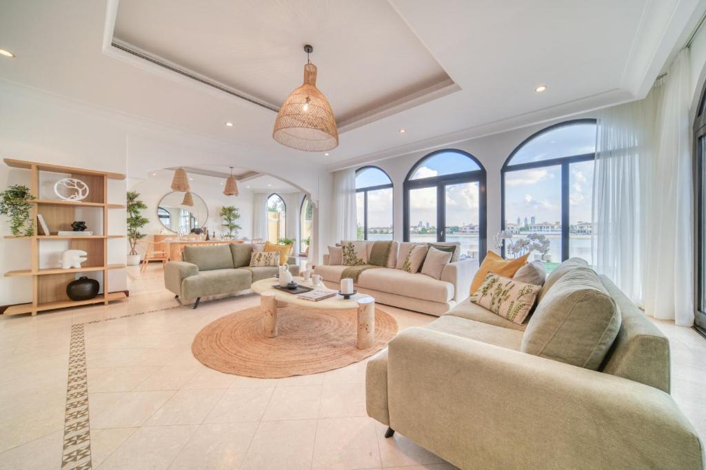 una gran sala de estar con sofás y una mesa. en Frond D Villa, Palm Jumeirah - Mint Stay, en Dubái