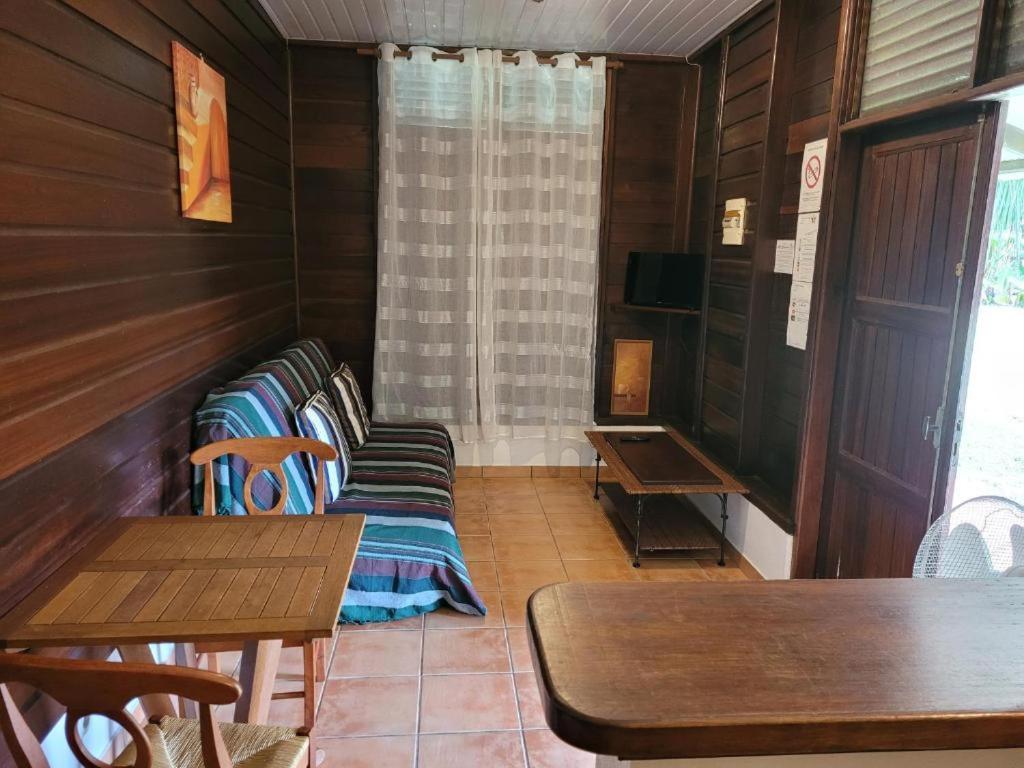 una camera con pareti in legno, tavoli e panche di Domaine de la Matourienne a Matoury
