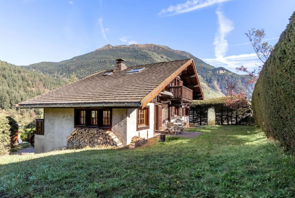 una pequeña casa con una montaña en el fondo en Chalet Eveland - Proche du centre-ville - Calme en Les Houches