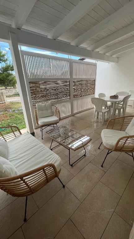 a patio with chairs and a table and chairs at Dimora Arnesano in Torre Lapillo