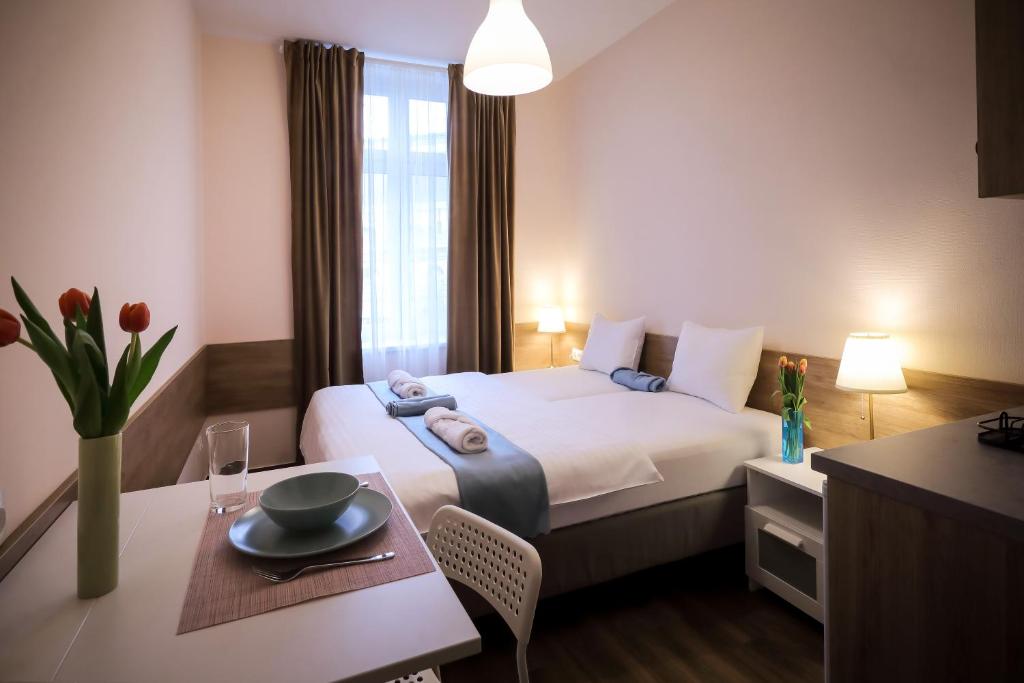 a hotel room with a bed and a table with a plate on it at East Station Comfort Plus in Budapest
