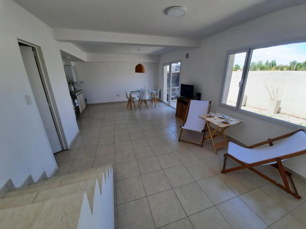 ein großes Wohnzimmer mit einem Tisch und Stühlen in der Unterkunft Dúplex con patio y parrilla en Terrazas del Sol in Neuquén