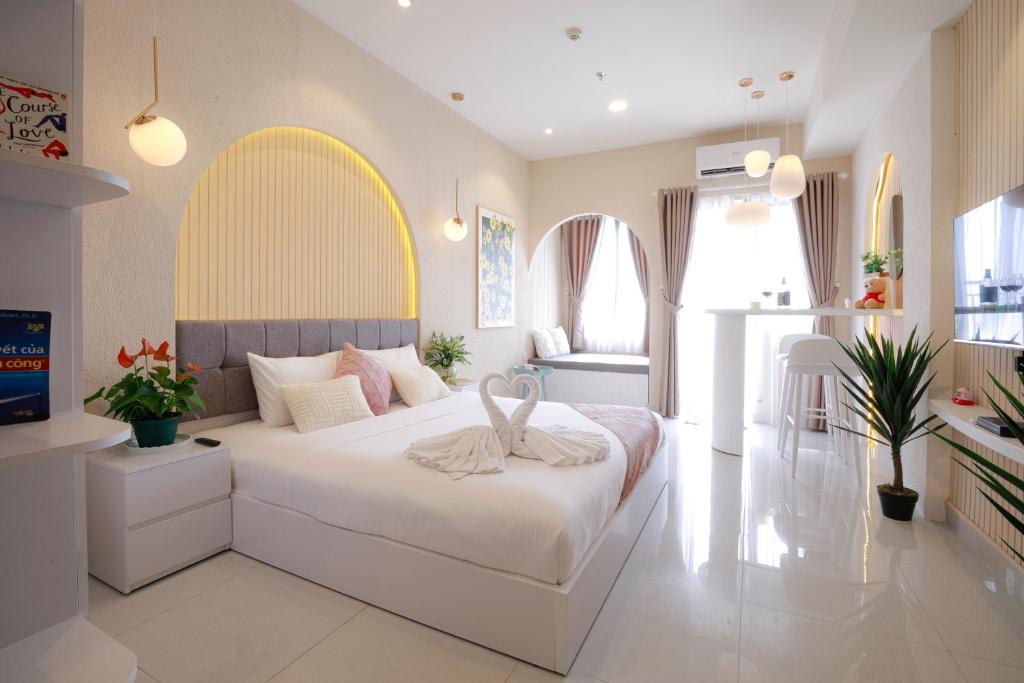 a bedroom with a large white bed with an arch above it at May Soho Saigon Serviced Apartment in Ho Chi Minh City