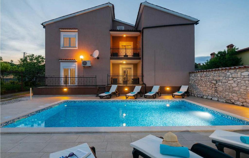 a villa with a swimming pool in front of a house at Villa Lara in Hreljići