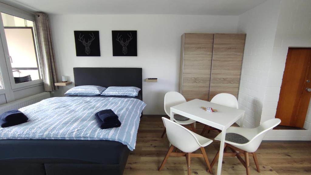 1 dormitorio con 1 cama, mesa y sillas en Ferienwohnung mit Blick in den Bayrischen Wald oberhalb von Sankt Engelmar, en Sankt Englmar