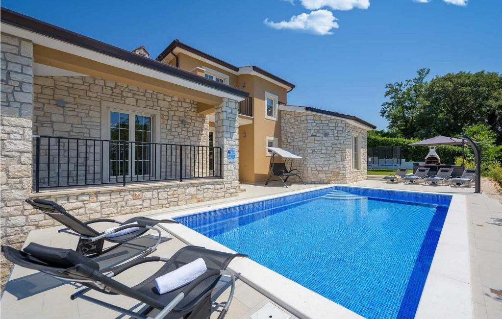 een zwembad met een stoel naast een huis bij Villa Simic in Poreč