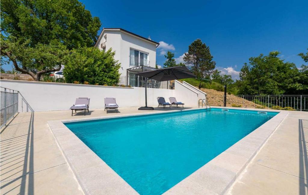 パジンにあるVilla Forest Fairyの椅子2脚と傘が備わったプール