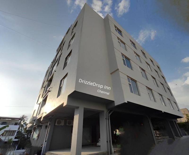 a large white building with a sign on it at DrizzleDrop Inn Chennai in Chennai