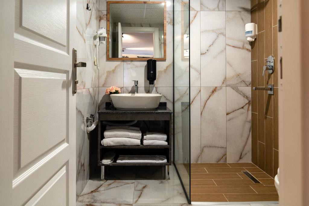 ein Bad mit einem Waschbecken und einem Spiegel in der Unterkunft Grand 464 Otel in Rize