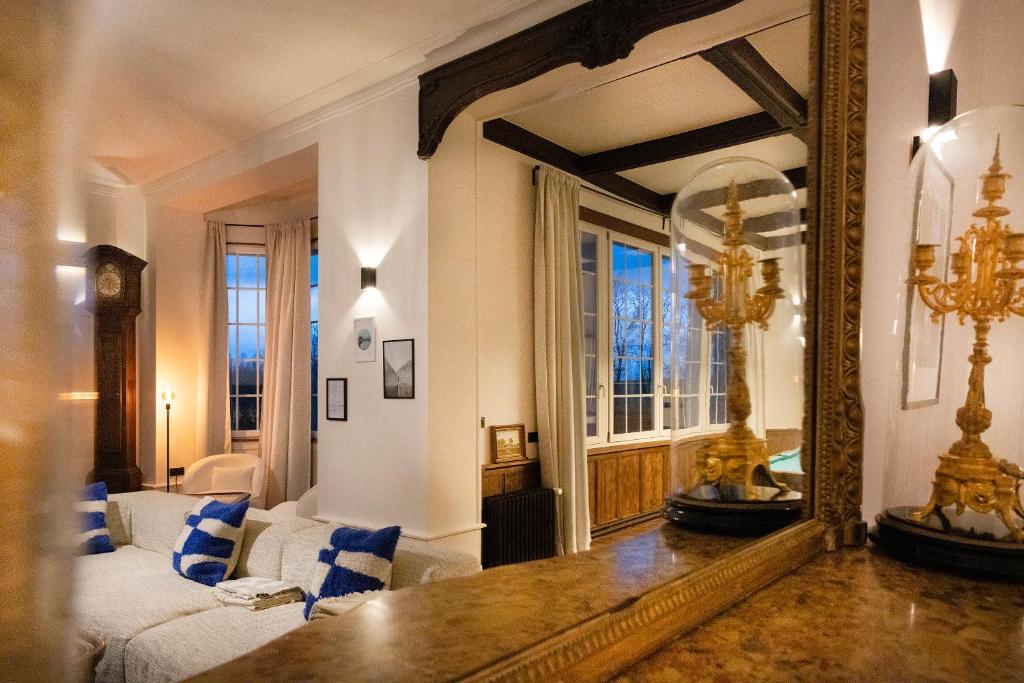 a living room with a mirror and a couch at Private Oasis: Luxe 20-guest Estate, Jacuzzi, 8 Ha in Bazeilles