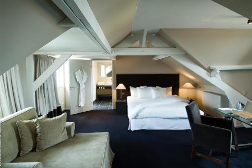 ル・テュケ・パリ・プラージュにあるPol Hotelのベッドとソファ付きのホテルルーム