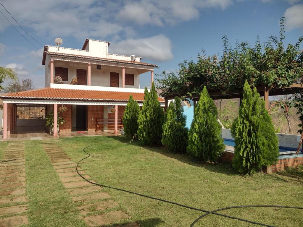 a house with a pool in front of a yard at CHACÁRA SOL NASCENTE in Lavras da Mangabeira