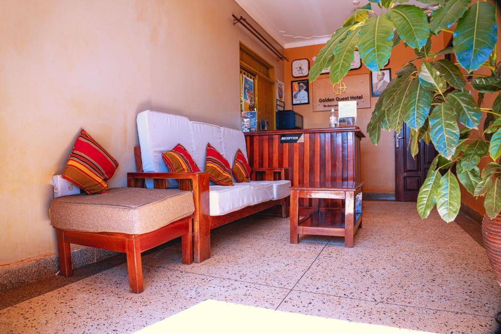 un soggiorno con divano e sedia di GOLDEN QUEST HOTEL a Entebbe