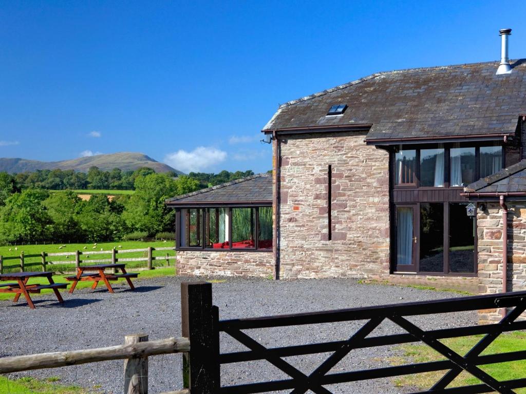 5 Bed in Brecon BN038 في Llanspyddid: مبنى أمامه كراسي وسياج