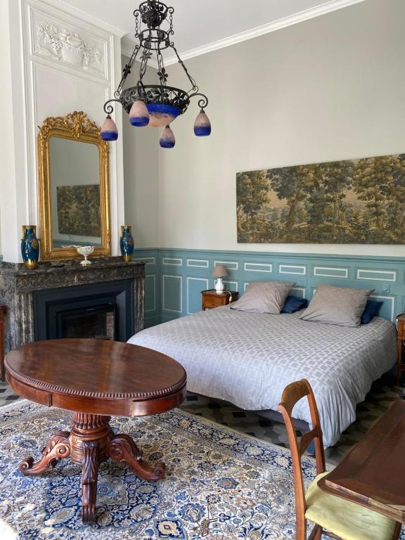 1 dormitorio con cama, mesa y espejo en Maison d'Hôtes de La Rivière en Pexiora