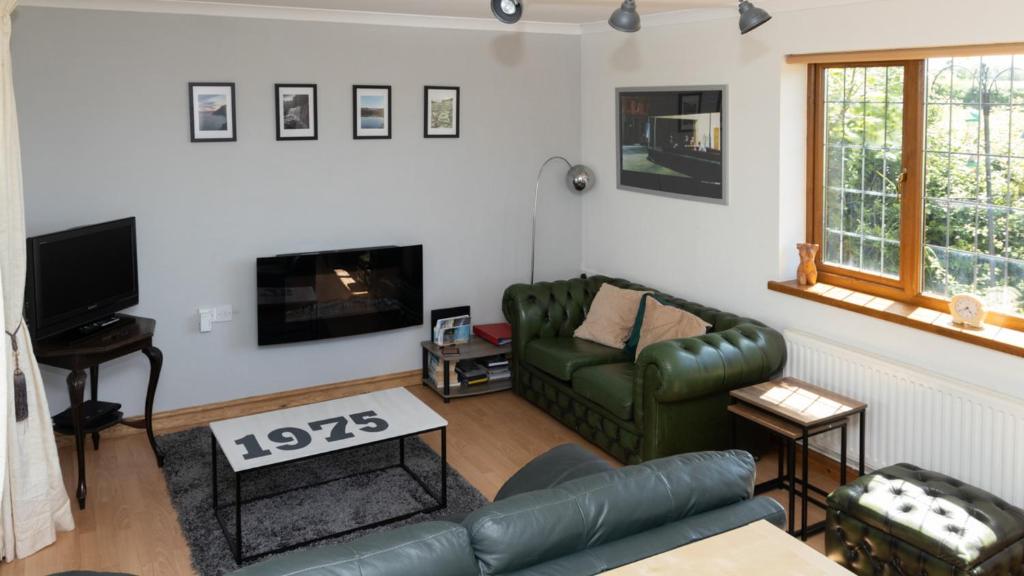 a living room with a couch and a tv at The Annexe At 53 in Bishopston