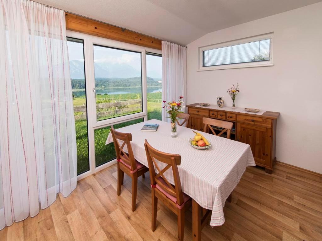 ein Esszimmer mit einem Tisch, Stühlen und einem Fenster in der Unterkunft Ilsenhof am Turnersee in Obersammelsdorf
