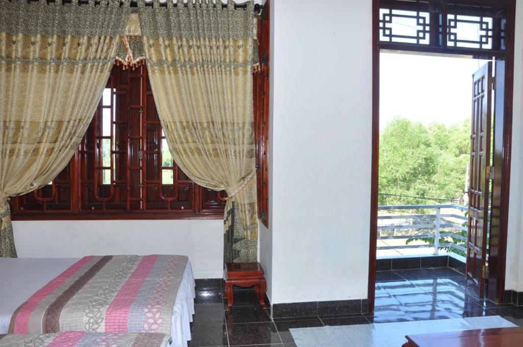a bedroom with a bed and a large window at Anh Tuấn Motel in Hue