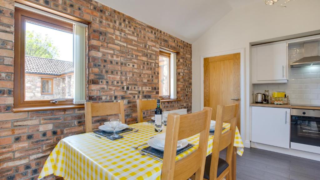 eine Küche und ein Esszimmer mit einem Tisch und Stühlen in der Unterkunft Daffodil Cottage in Penclawdd
