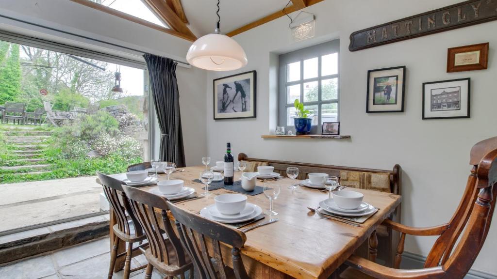 a dining room with a wooden table and a large window at Ship Cottage in Bishopston