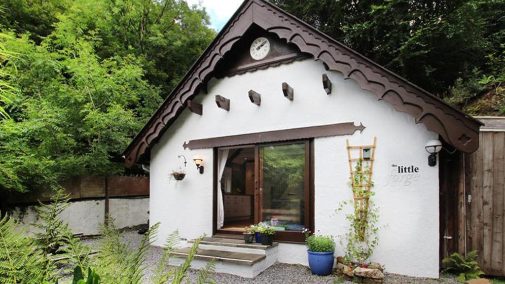 a small white house with a brown roof at The Little Forge in Parkmill